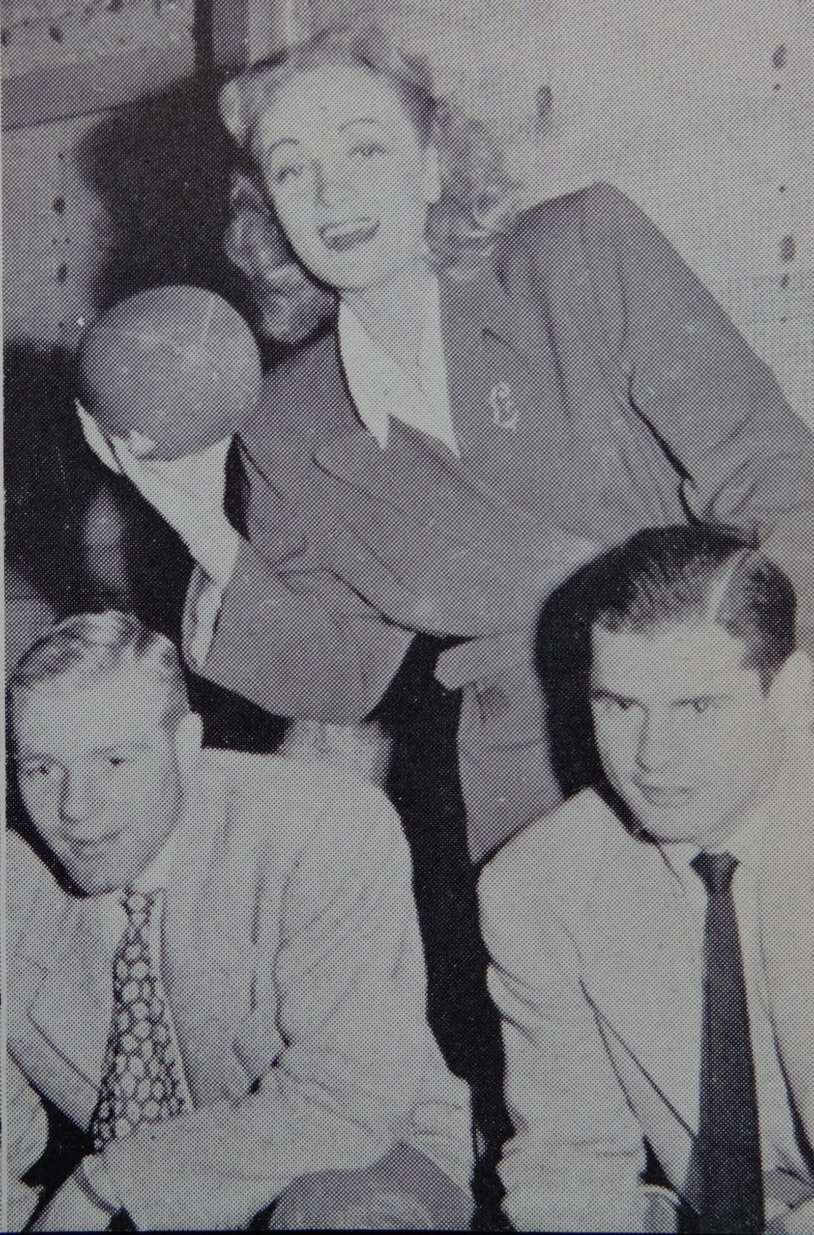 Photograph of University of Michigan football players Bump Elliott and Bob Chappuis pose with Marlene Dietrich