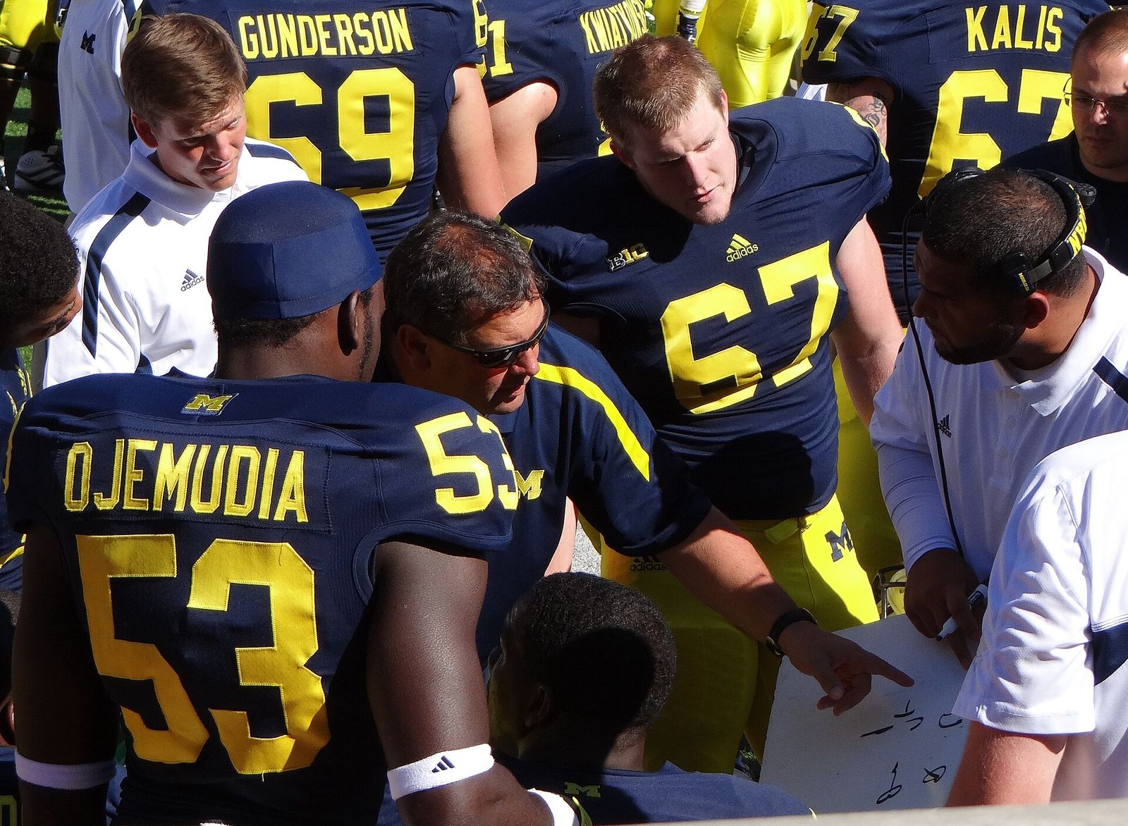 Michigan head coach Brady Hoke and defensive line coach Jerry Montgomery work on the sidelines with Michigan's defensive linemen