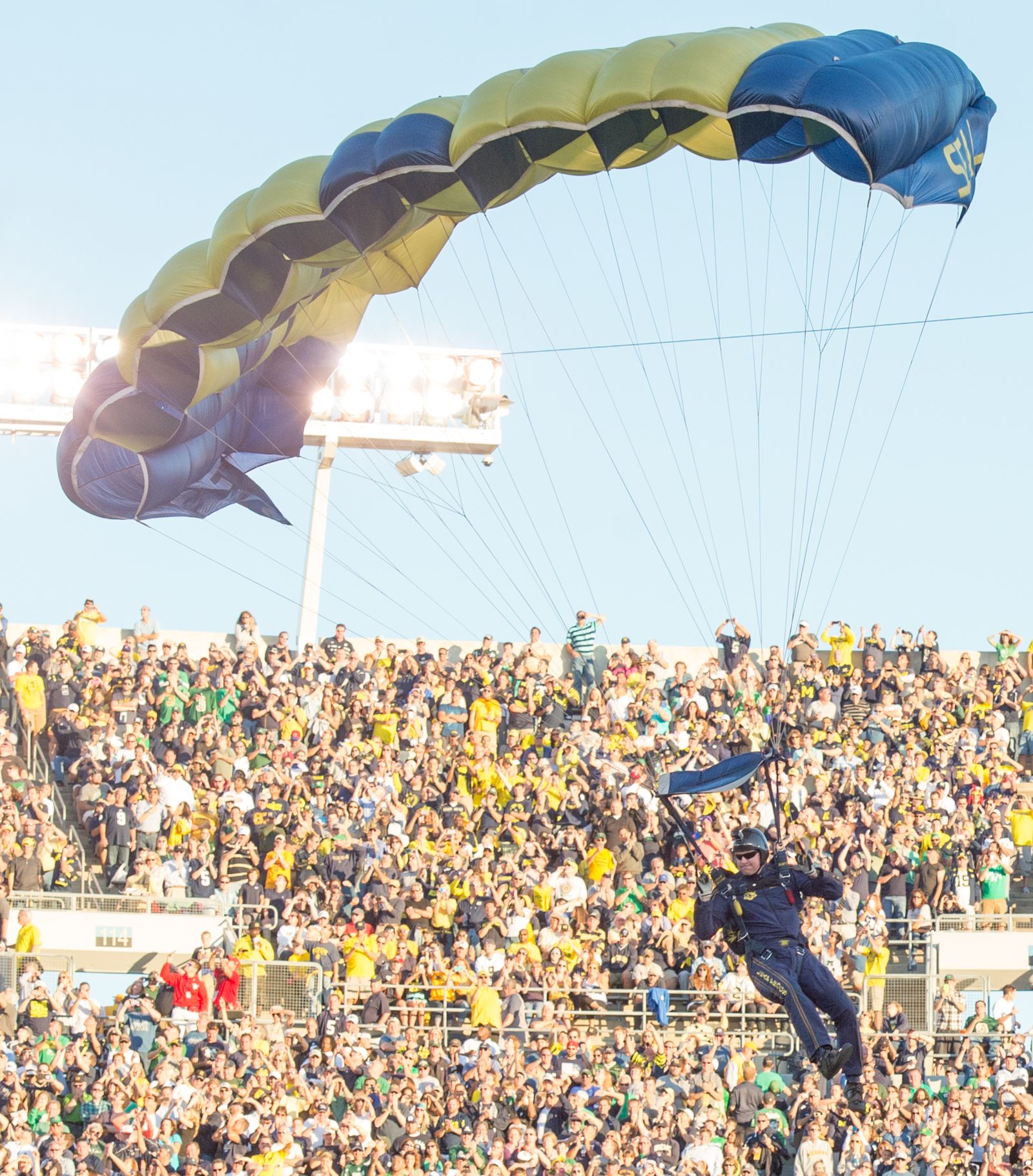 A U.S. Sailor with the Leap Frogs parachutes onto the field at Notre Dame Stadium in South Bend, Ind., Sept. 6, 2014, before a football game.
