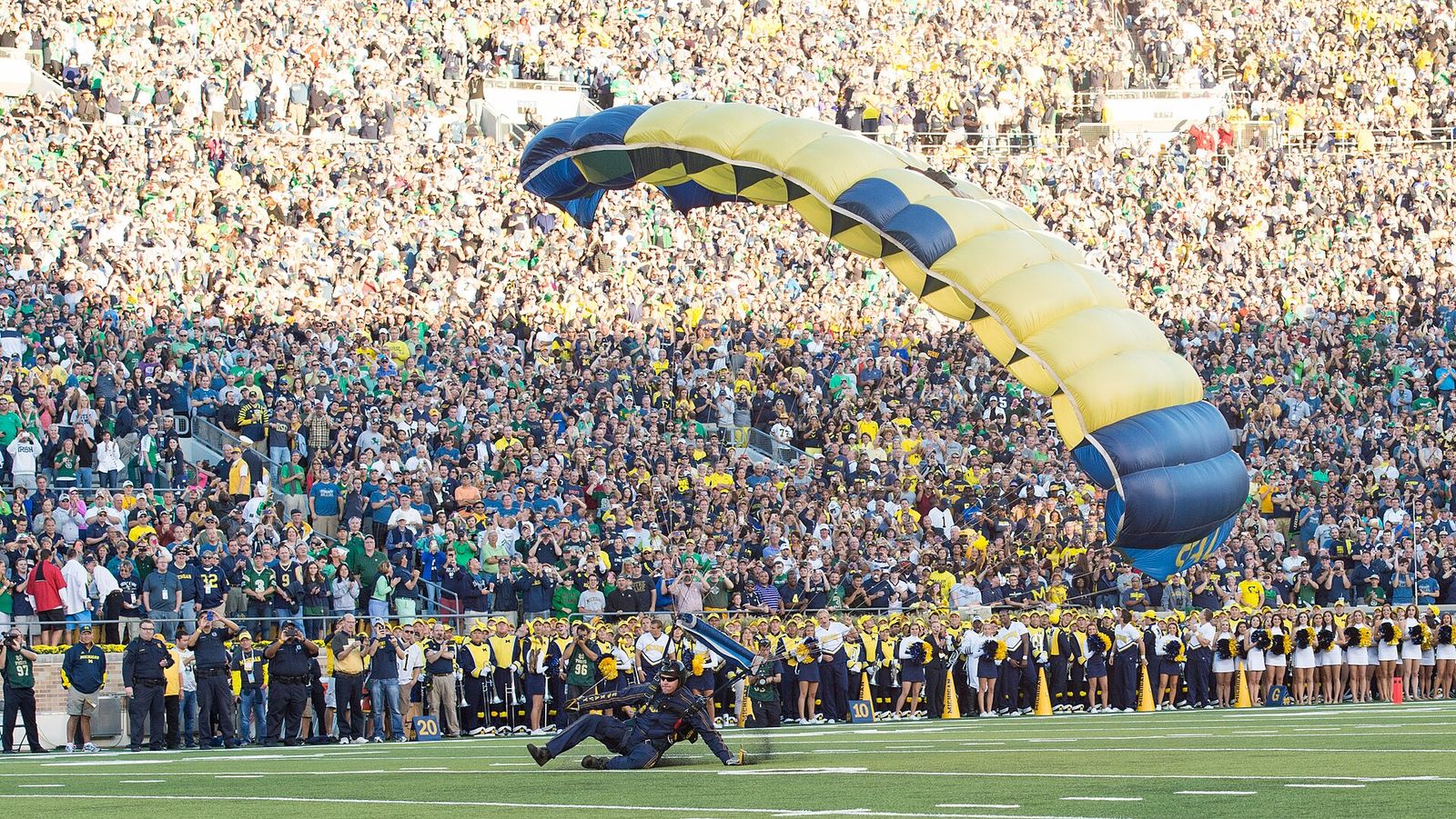 A U.S. Sailor with the Leap Frogs parachutes onto the field at Notre Dame Stadium in South Bend, Ind., Sept. 6, 2014, before a football game.