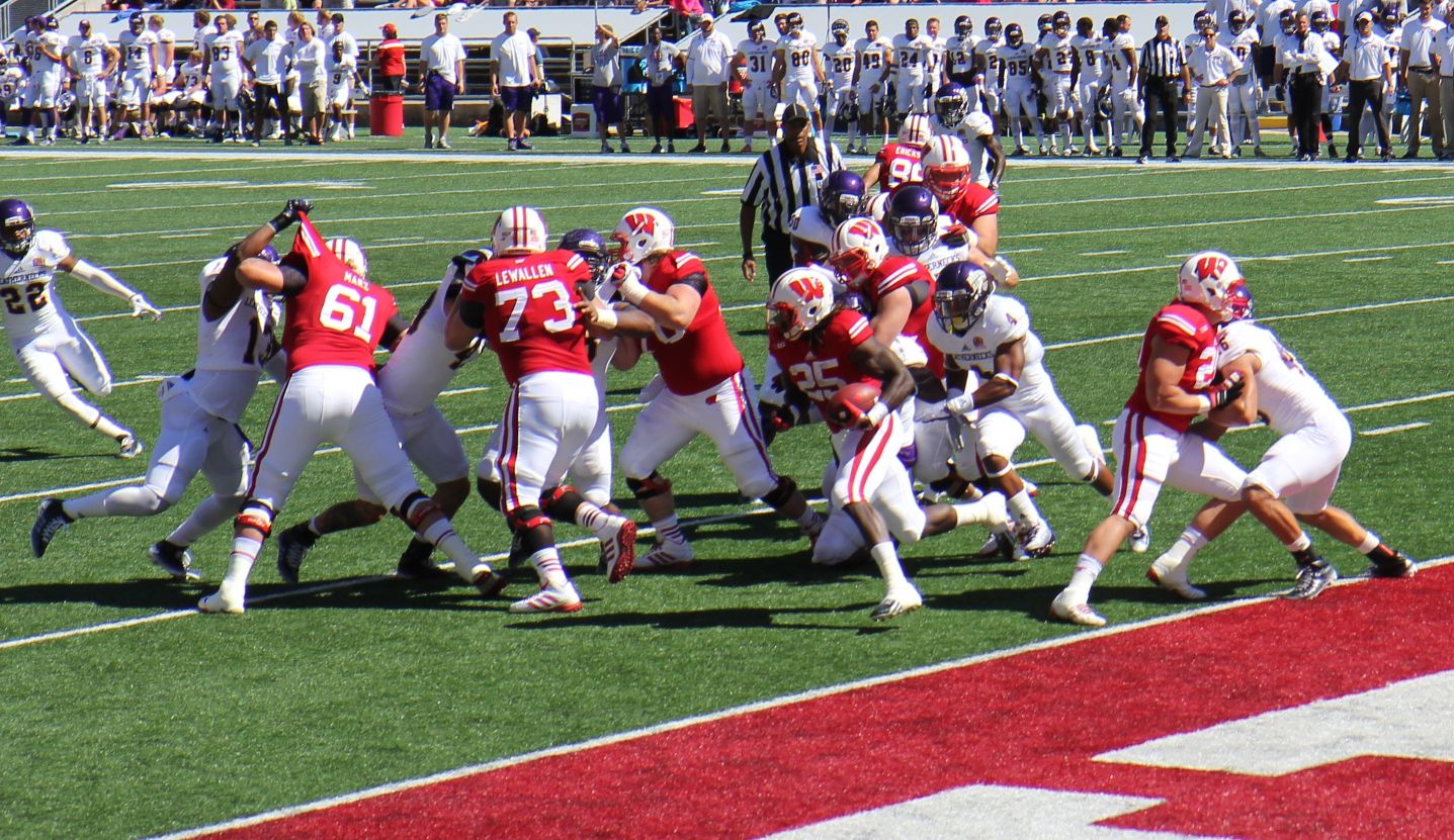 The Wisconsin Badgers offensive team blocking for rusher Melvin Gordon] III (#25) against the Western Illinois Leathernecks