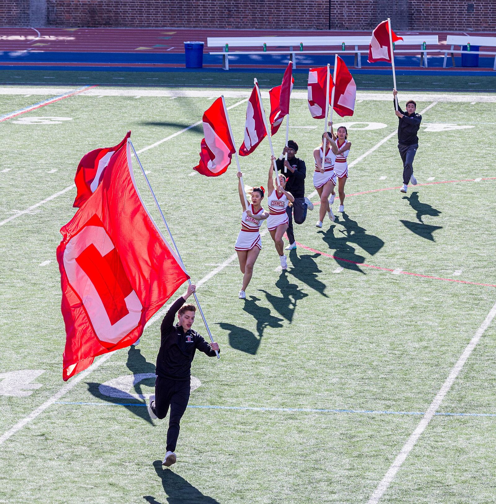 C - O - R - N - E - L - L flags carried by Cornell University cheerleaders. Cornell at Penn football, November 9, 2019.