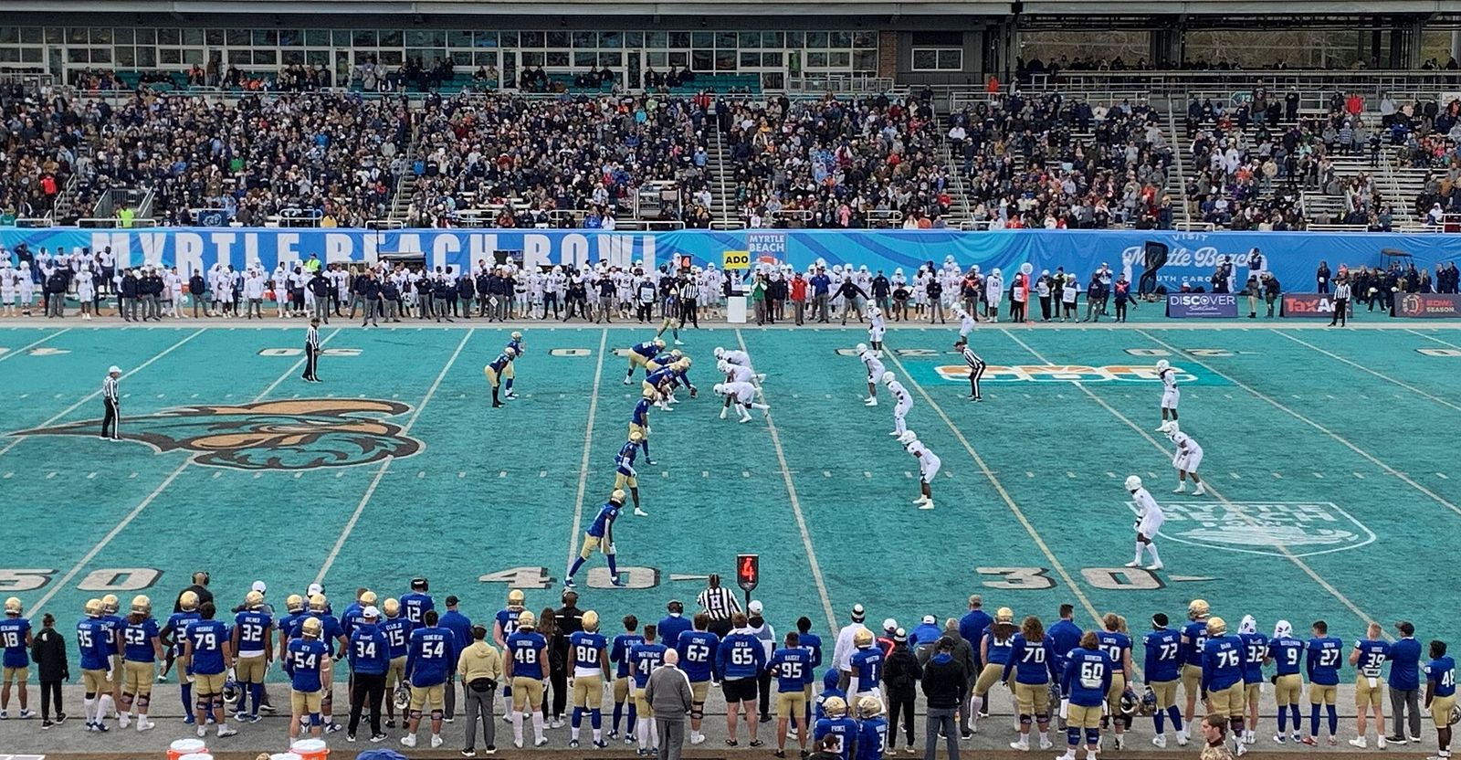 Tulsa (blue, on offense) lined up at the line of scrimmage against Old Dominion (white, on defense) at the 2021 Myrtle Beach Bowl