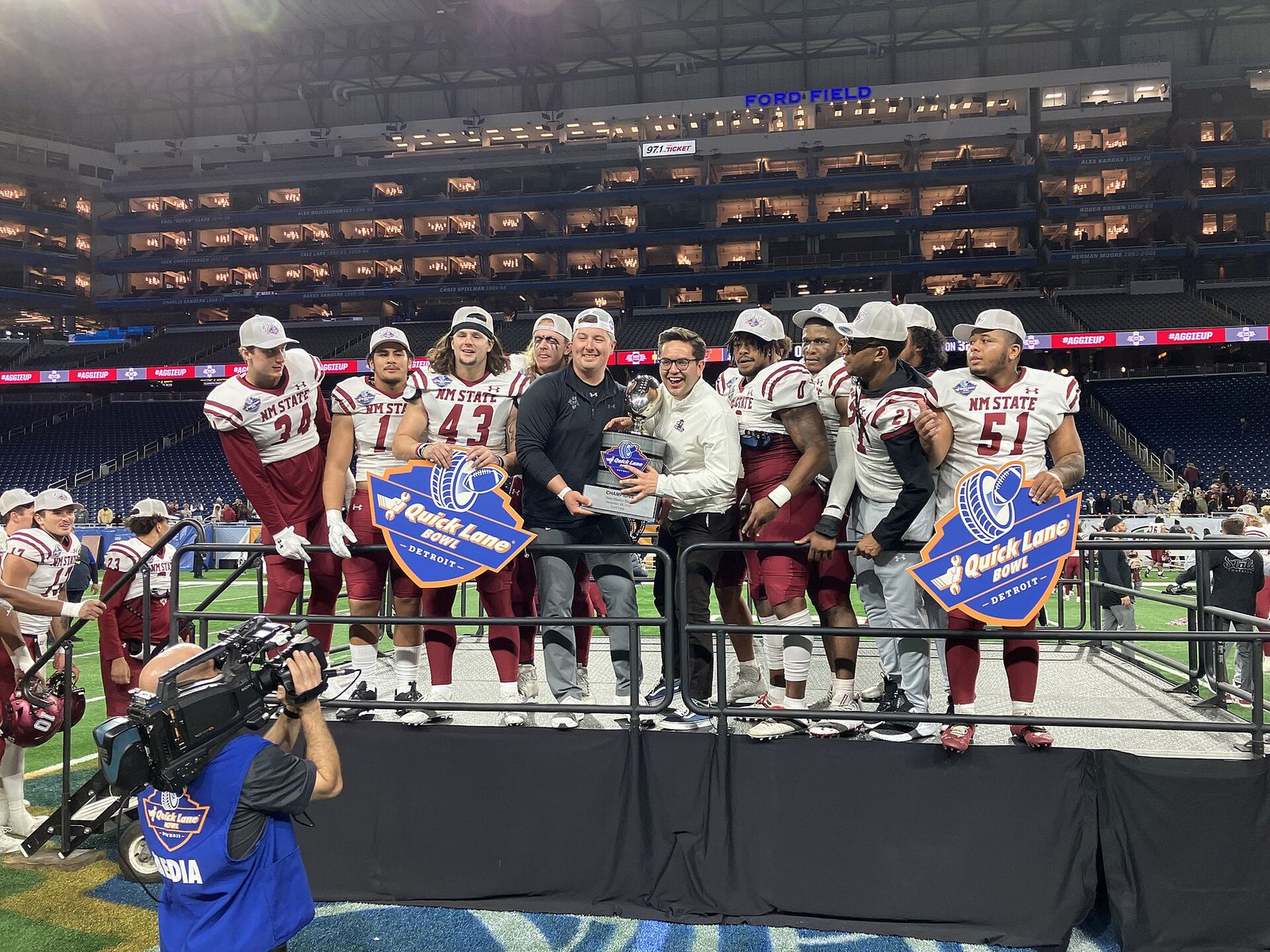 NMSU players celebrate with 2022 Quick Lane Bowl trophy