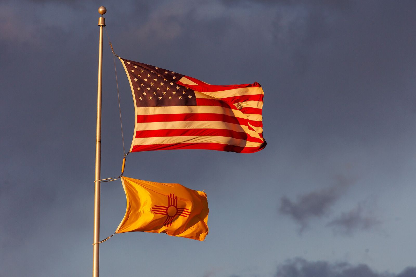 Flags of United States and New Mexico fly over University Stadium at the University of New Mexico.