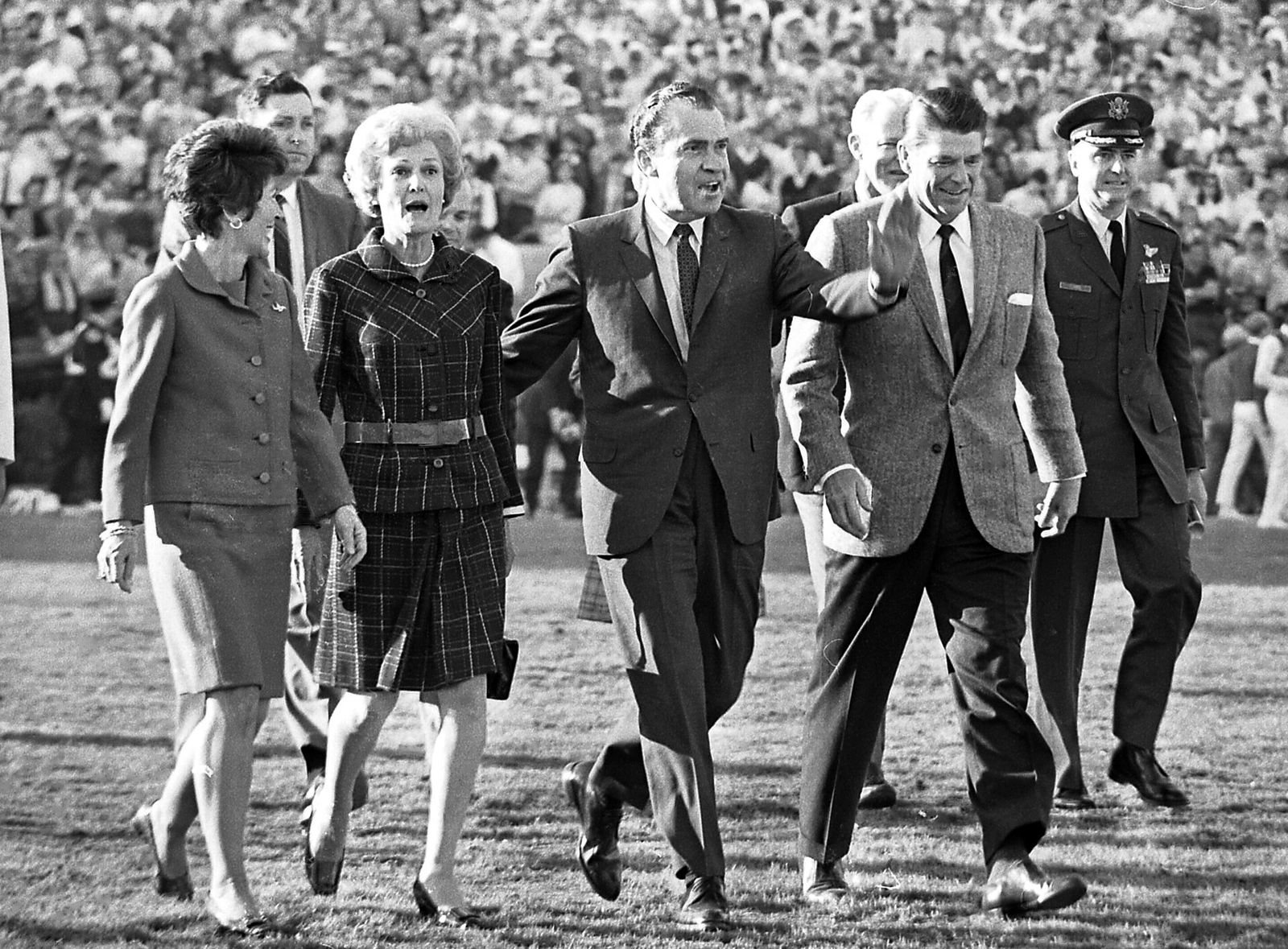From left, Nancy Reagan, Pat Nixon, Richard Nixon and Ronald Reagan walking across field at 1969 Rose Bowl game
