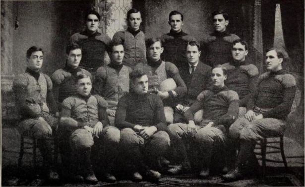Team captain Cone is seated in the center of the photo, holding football