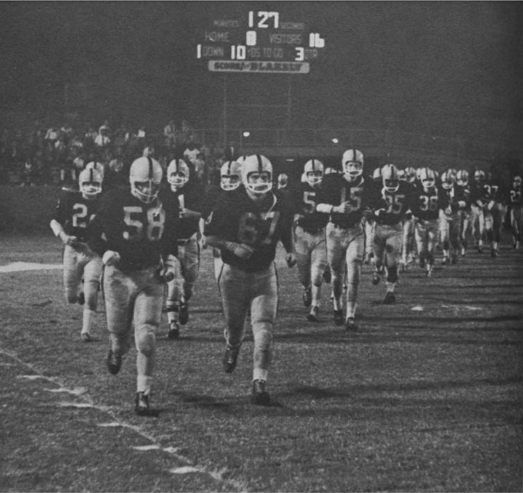 Photograph of 1961 football team trotting onto the field (from The Sahuaro 1962)
